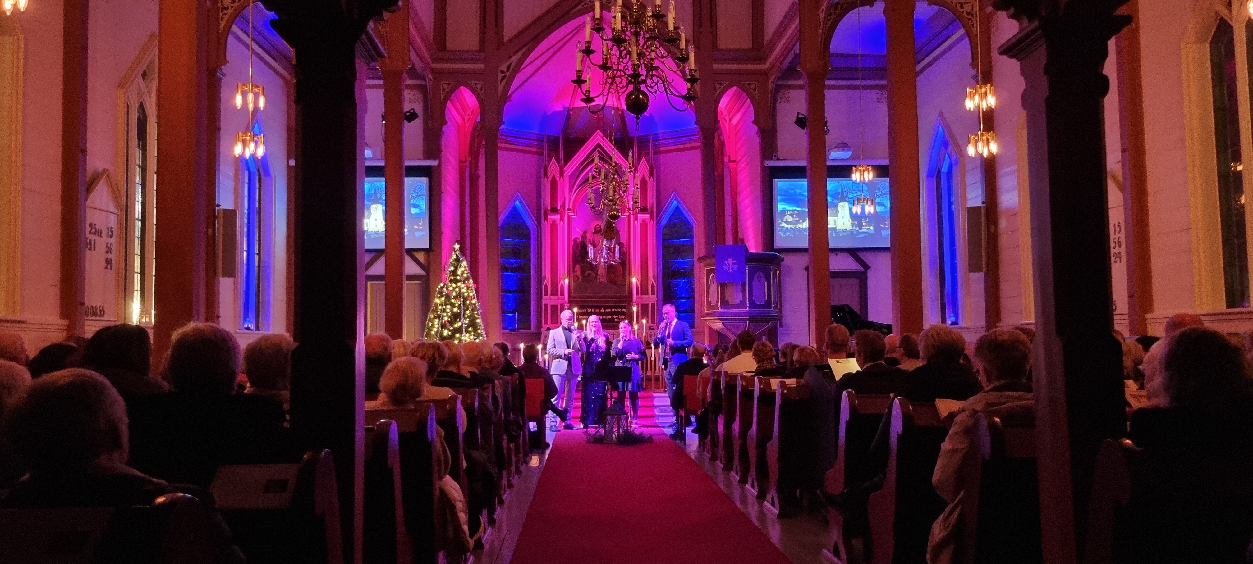 Regine, Arvid, Maria og Tor Håkon står og synger framme i kyrkja